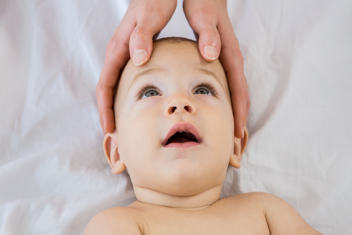 Mamma che massaggia il neonato