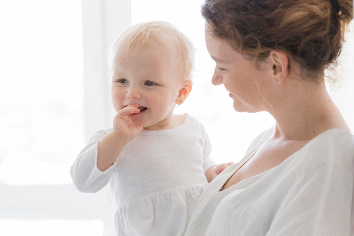 Mamma con bambino in braccio e dentini doloranti